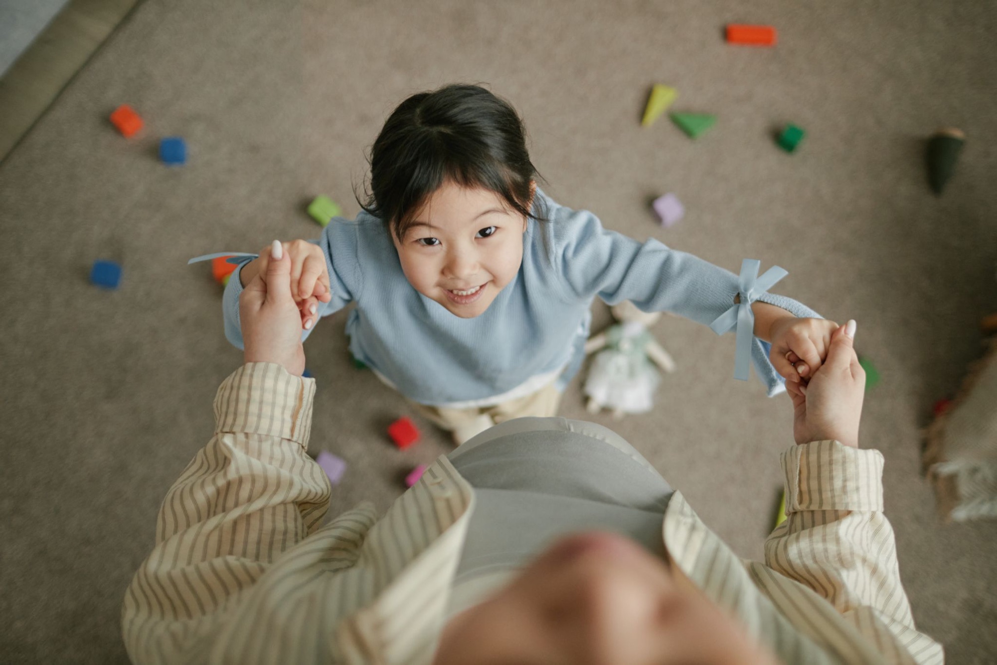 孩子握著大人的雙手,抬頭微笑